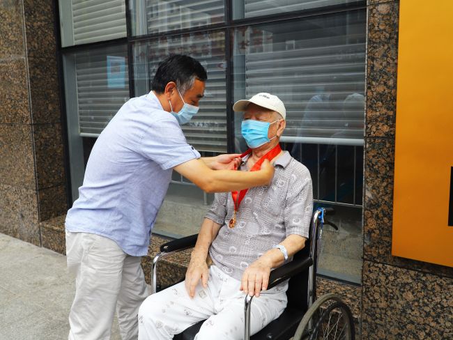 汪启来为张建党佩带“庆幸在党50年”留想章（建图）.jpg